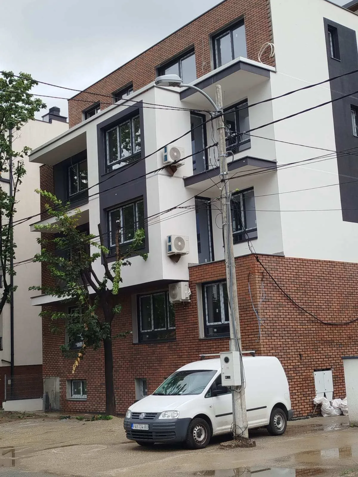 Novoizgrađeni stambeni objekat sa fasadom od cigle i belog maltera — radovi Adaptera, Beograd